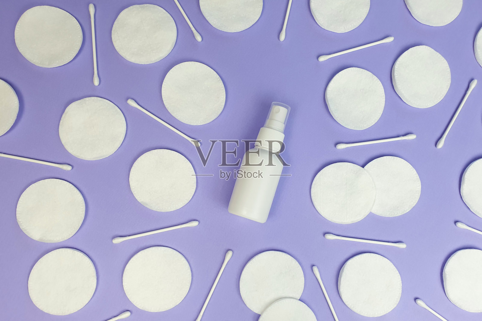 无品牌白色塑料喷瓶模型和棉垫图案在紫色的背景。俯视图，平面，生活方式。清洁美容和液体抗菌喷雾概念。照片摄影图片