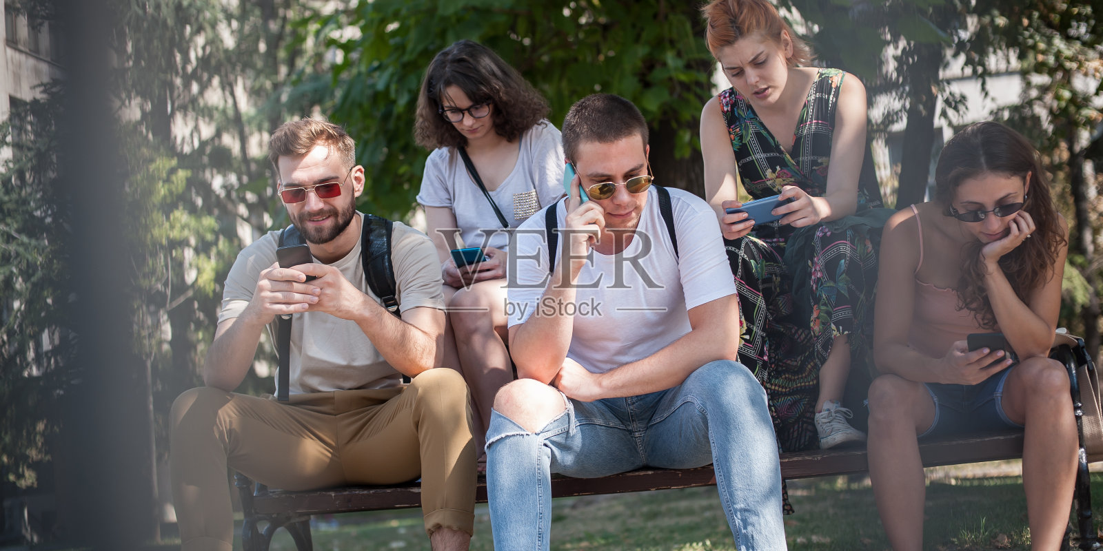 一群使用智能手机的朋友。情绪孤立和科技抑郁照片摄影图片