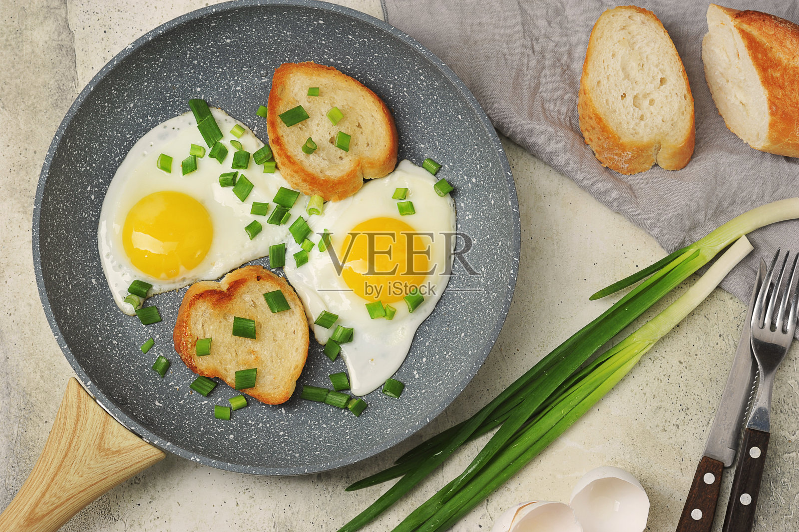 早餐有煎蛋，大葱和法式长棍面包照片摄影图片