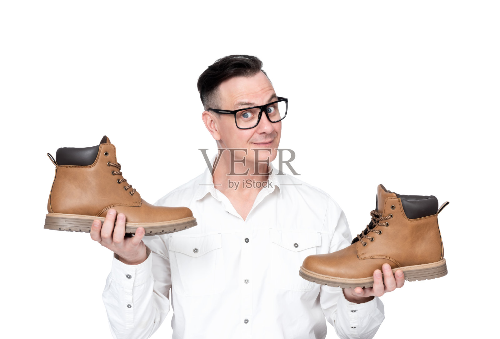 微笑积极的商人穿着白色衬衫和眼镜微笑着展示他的双手两只鞋，孤立在白色的背景照片摄影图片