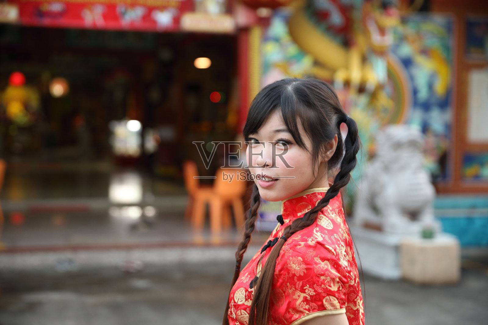 美丽的女人穿着红色旗袍看着和微笑在中国新年照片摄影图片