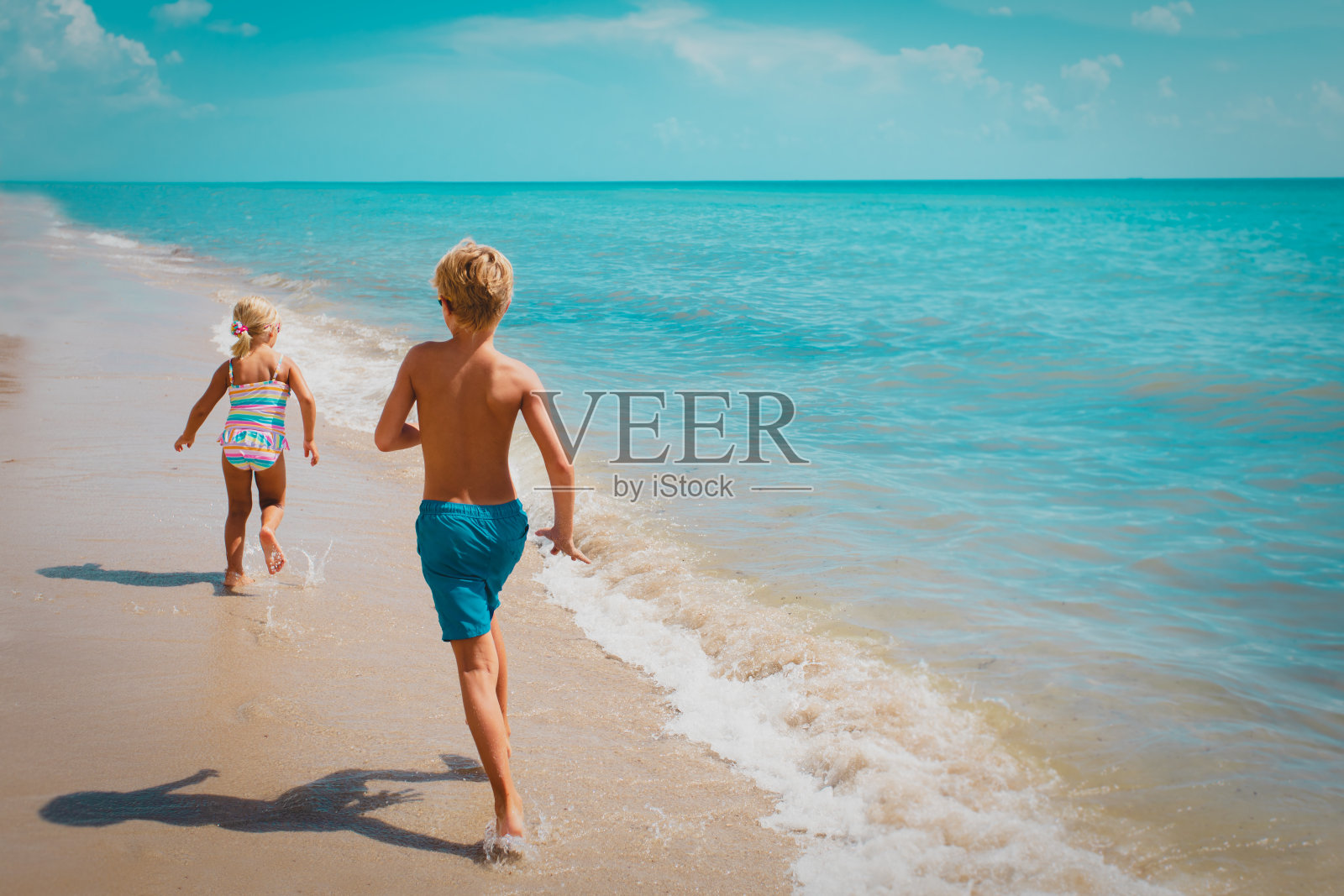 孩子们跑着，男孩和女孩在热带海滩上玩得很开心照片摄影图片