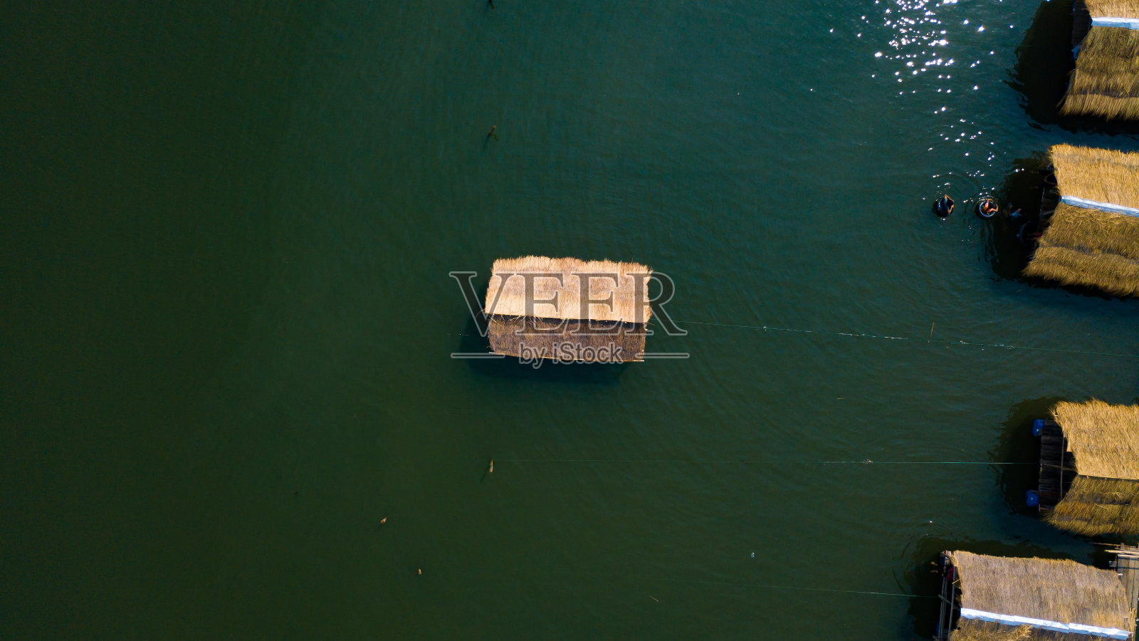 湖面上竹筏村舍，阳光倒映水面照片摄影图片