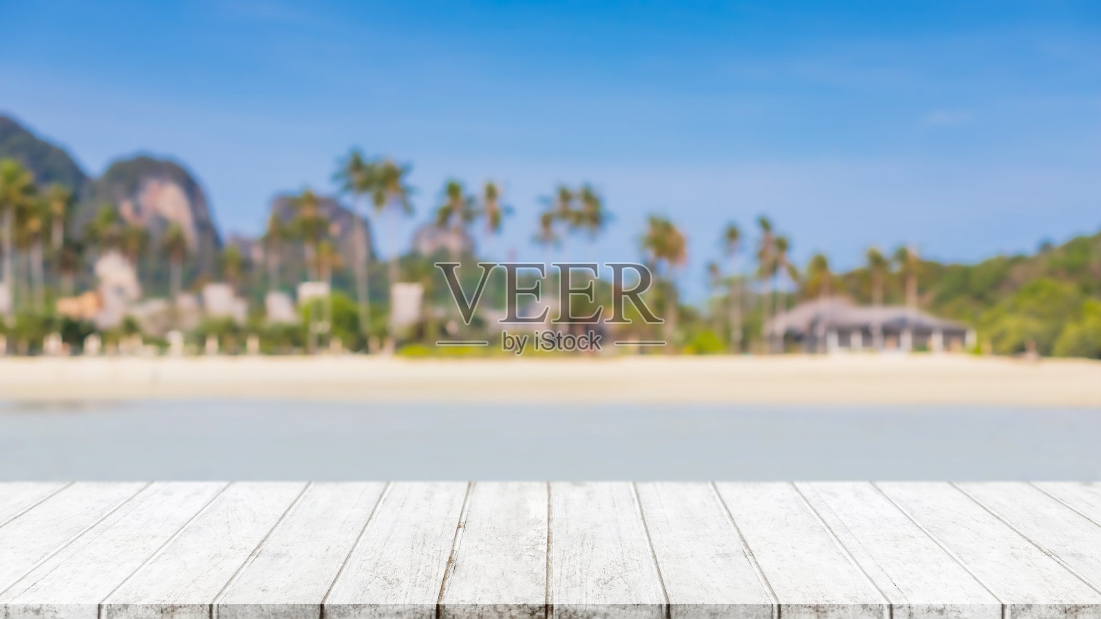 空的木头桌面和模糊的夏季海滩在热带度假胜地的旗帜背景-可以用来展示或蒙太奇您的产品。照片摄影图片