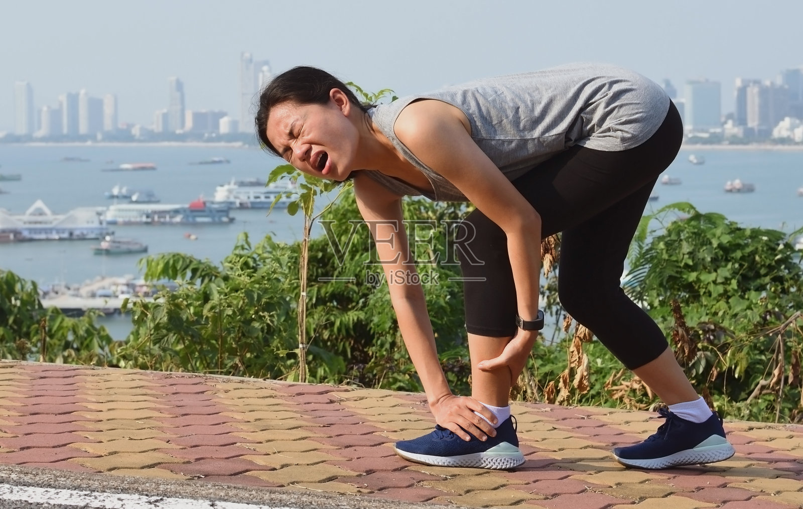 跑步女子在跑步训练中痛苦地尖叫。照片摄影图片