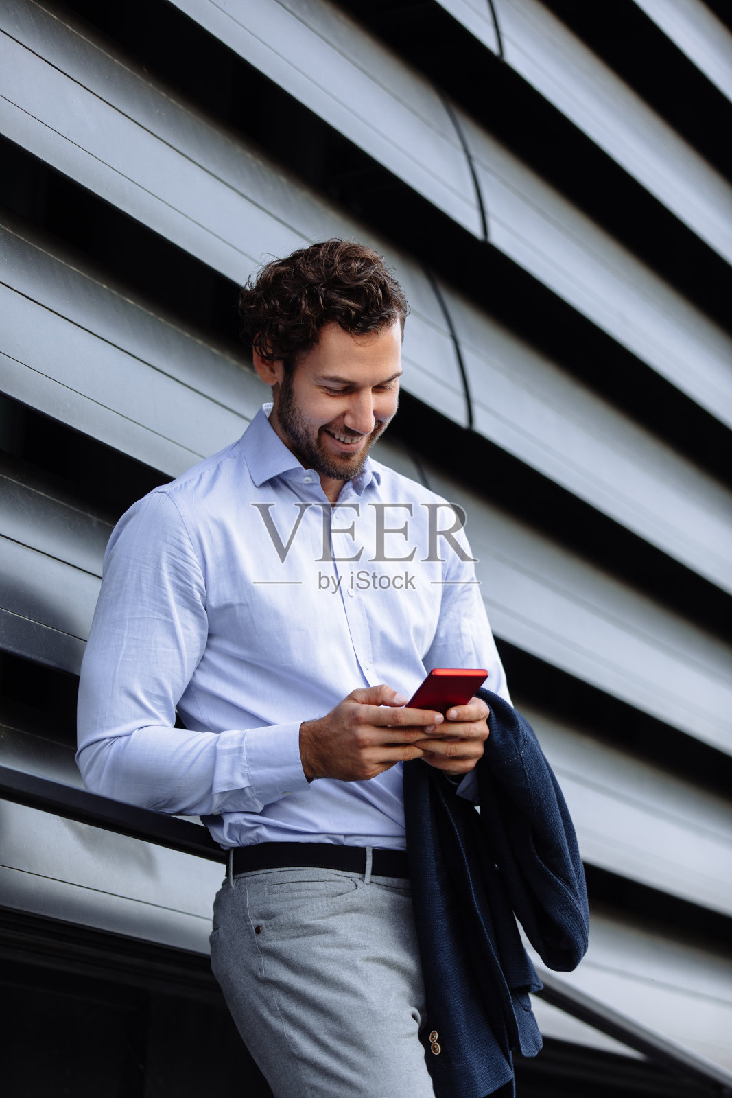 一个年轻商人在户外用智能手机的肖像照片摄影图片