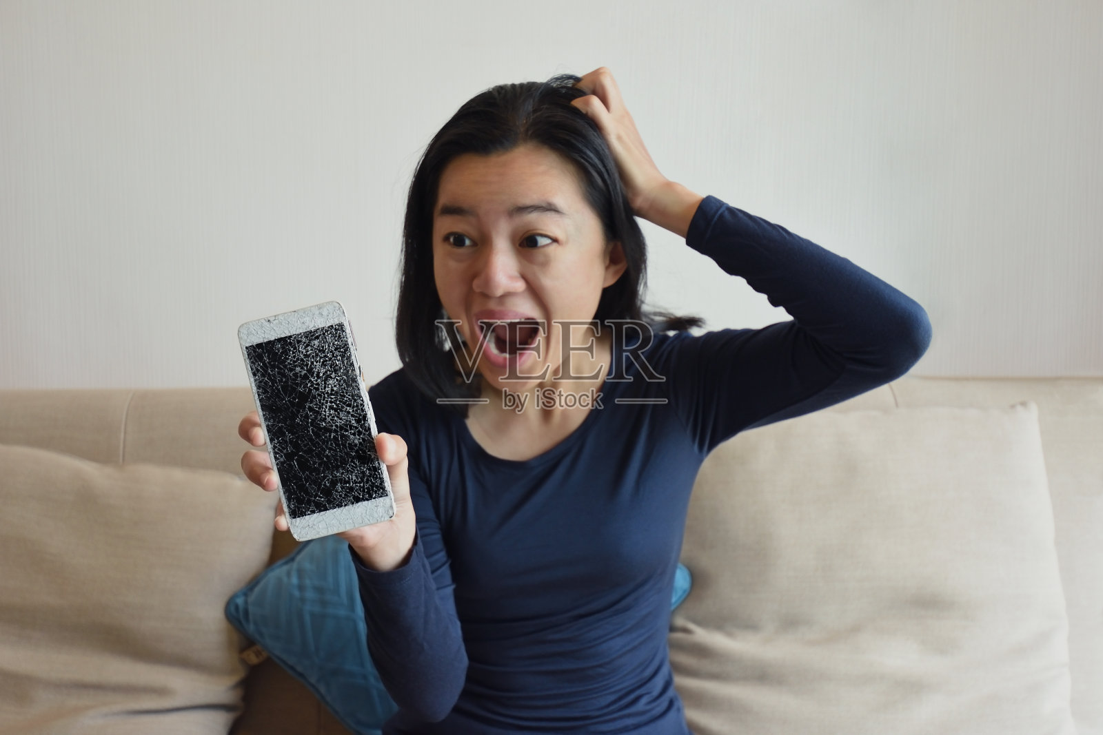困惑愤怒的女人在家里的沙发上有电话的问题照片摄影图片