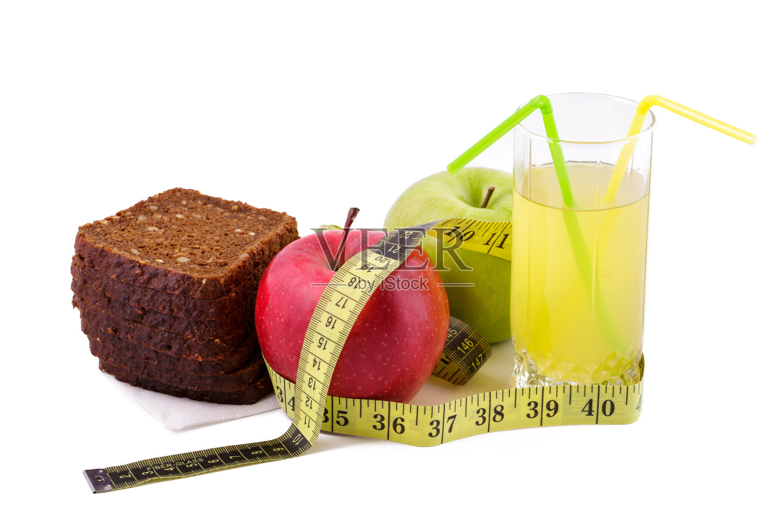 黑麦面包，绿苹果和红苹果，果汁装在一个白色盘子里，用黄色的卷尺。饮食与健康食品理念照片摄影图片