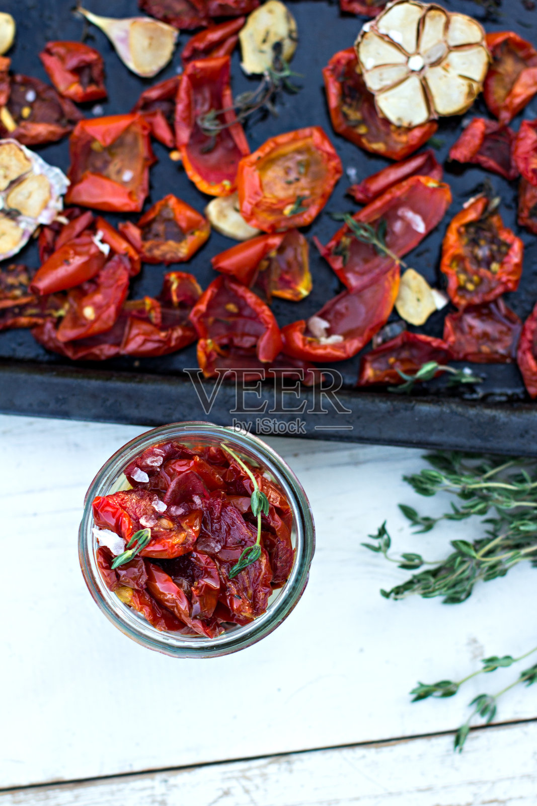 晒干的西红柿。晒干的番茄，香草和大蒜，木质背景。照片摄影图片
