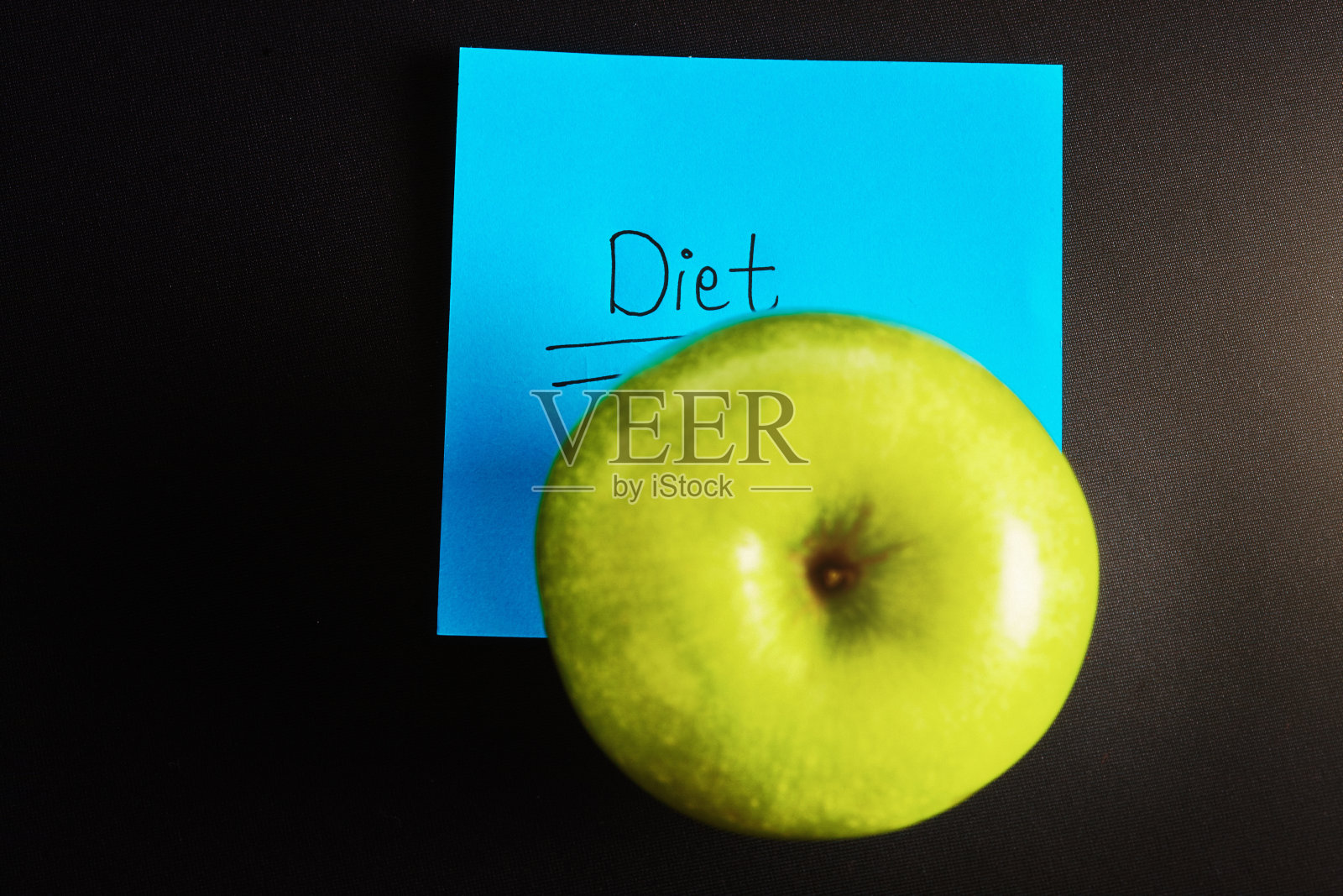 贴在便签上的“节食”一词，上面还有新鲜、熟透的青苹果照片摄影图片