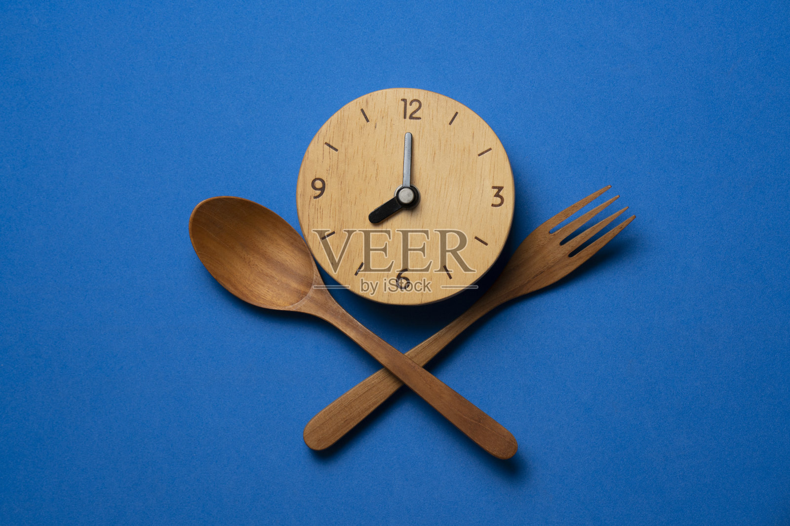 食物时钟勺子和叉子，蓝色背景上的健康食物早餐概念照片摄影图片