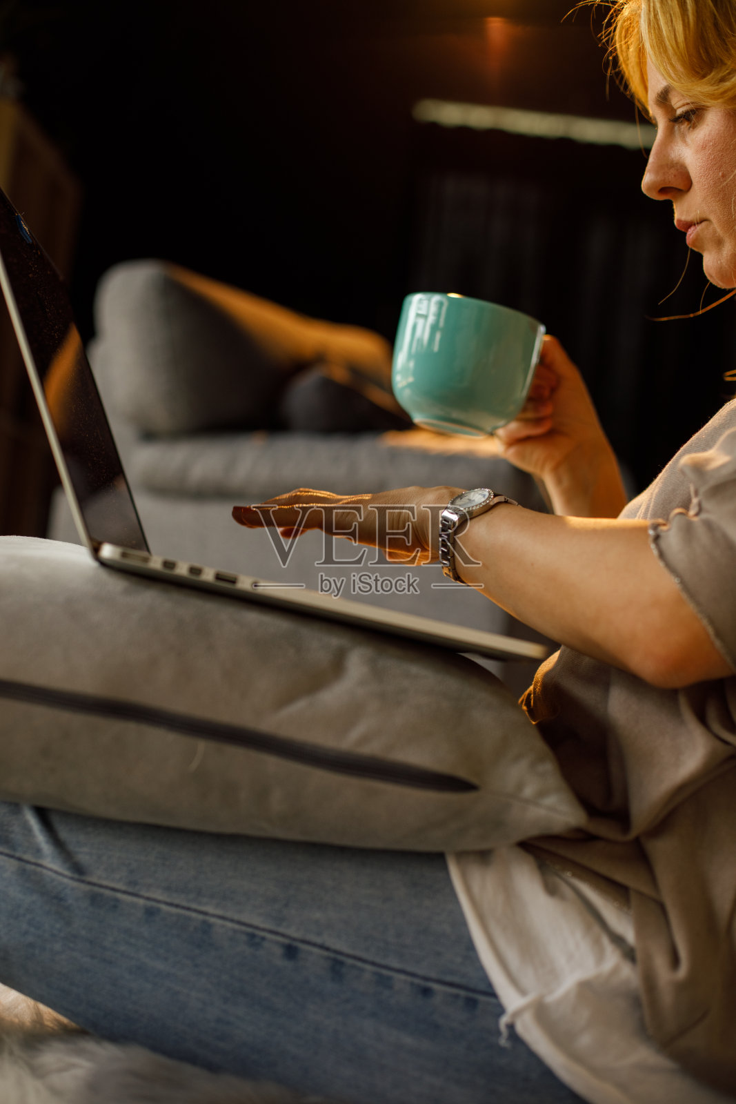 女人在笔记本电脑上写邮件，喝着咖啡照片摄影图片