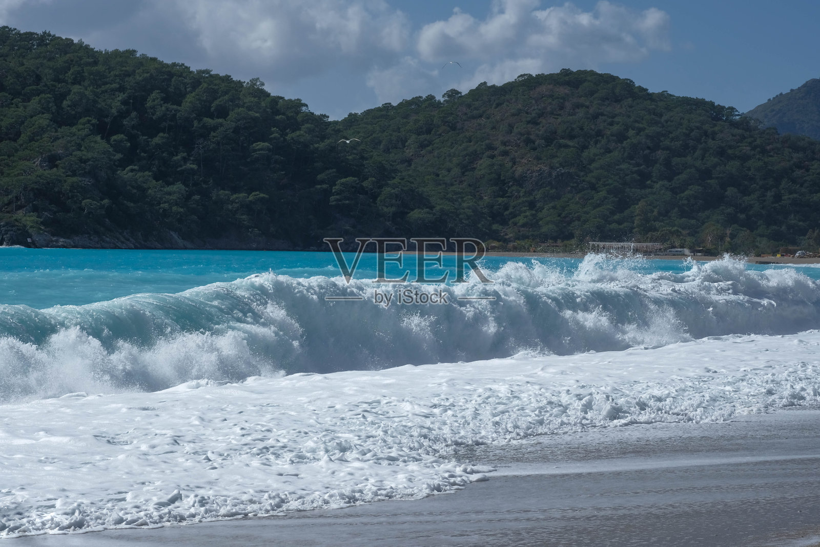 蓝色的波浪滚向沙滩照片摄影图片