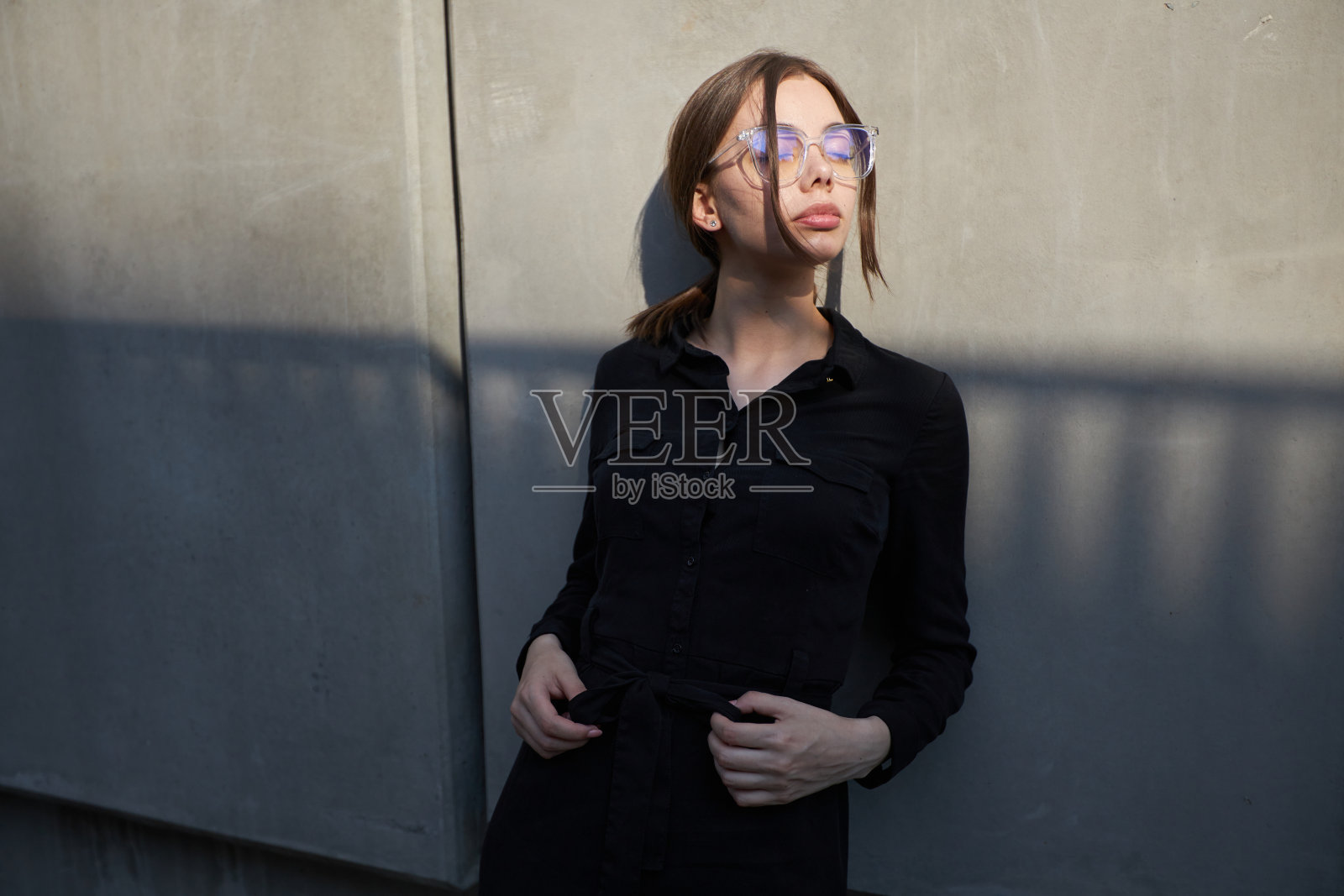 一个性感的黑发女人在日落时分穿着黑色衣服在市区外的时尚大头照照片摄影图片