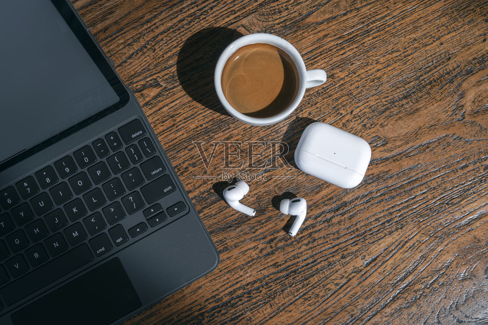 俯视图咖啡杯，耳机和平板电脑键盘木桌，舒适的工作概念。照片摄影图片
