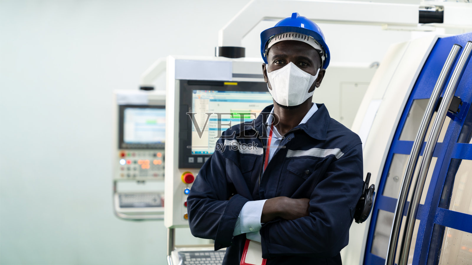 非裔美国工程师工人的肖像戴着外科手术口罩和双臂交叉在工厂照片摄影图片