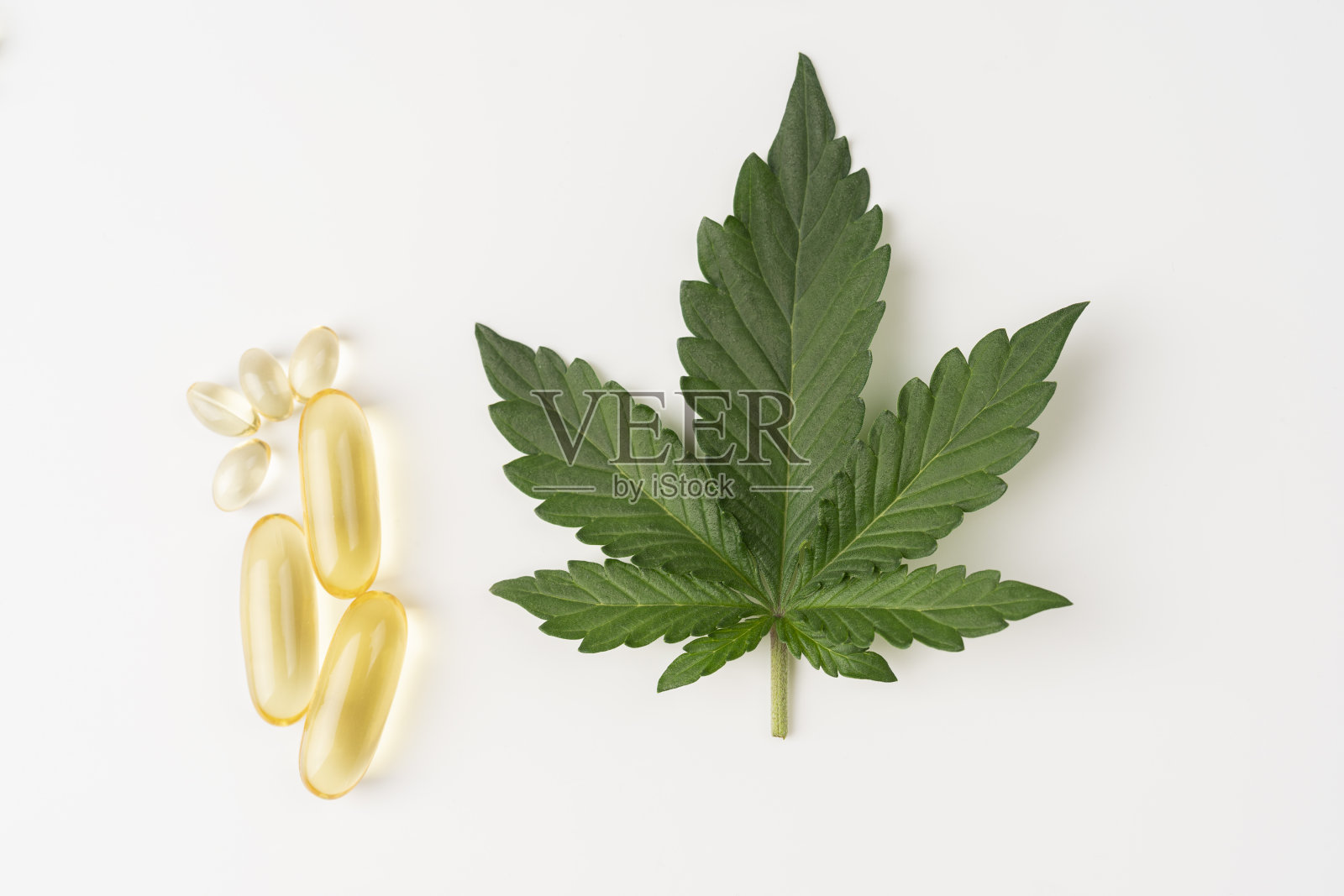 CBD油胶囊，药用大麻油胶囊，叶和胶囊分离在白色背景照片摄影图片