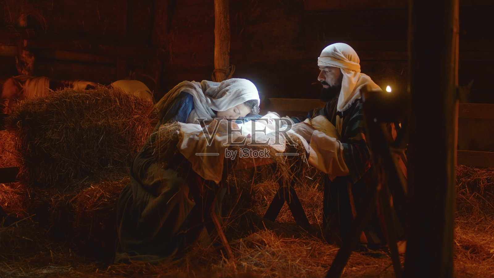 玛丽和约瑟夫在发光的马槽里抚摸婴儿耶稣照片摄影图片
