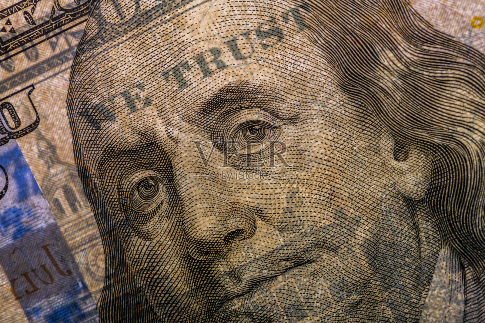 100美元纸币上的本杰明·富兰克林的背光肖像，WE TRUST在光线下可见照片摄影图片