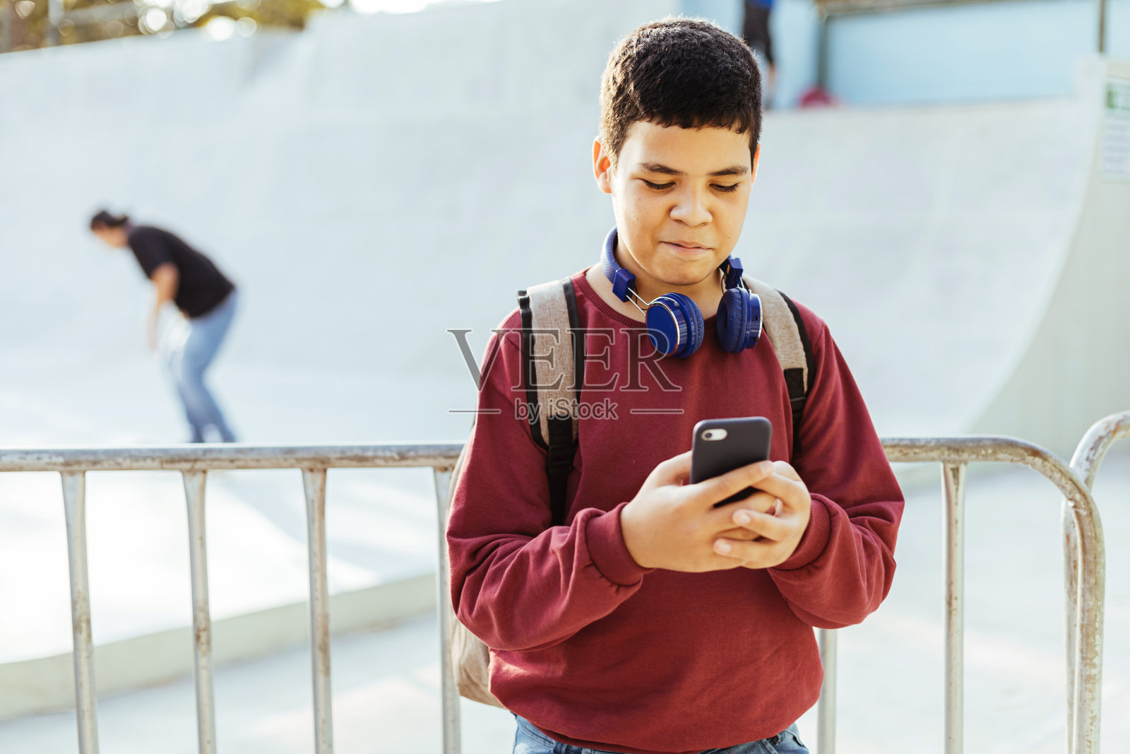 12岁男孩在户外使用智能手机。照片摄影图片