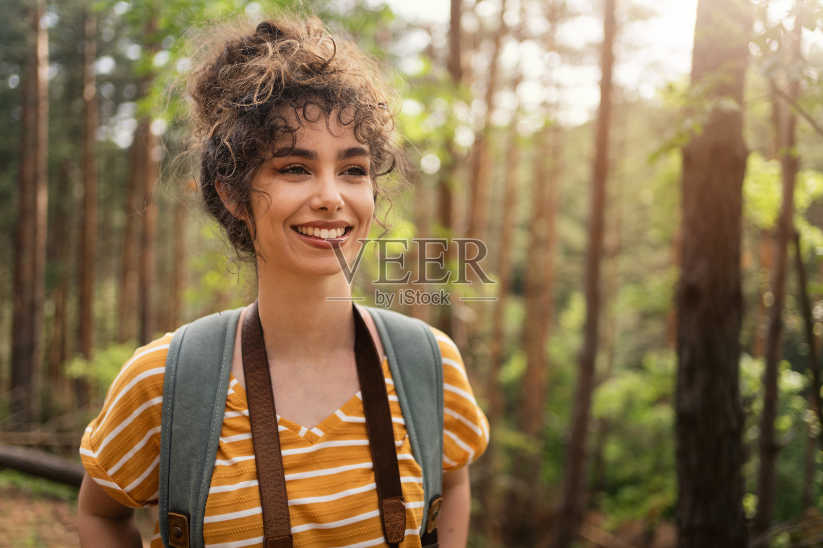美丽的年轻女摄影师的肖像与她的相机在森林照片摄影图片