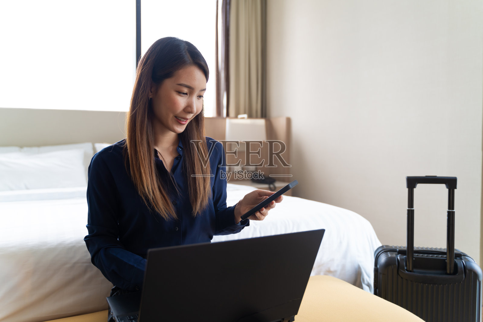 亚洲女商人使用笔记本电脑在酒店房间远程工作在她的商务旅行照片摄影图片