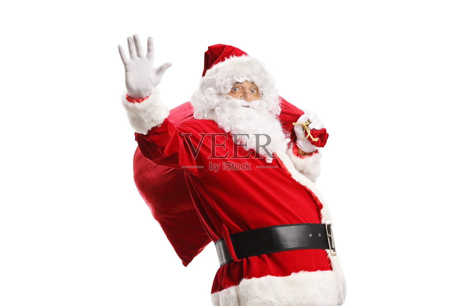 圣诞老人手里拿着一袋礼物，挥手致意照片摄影图片