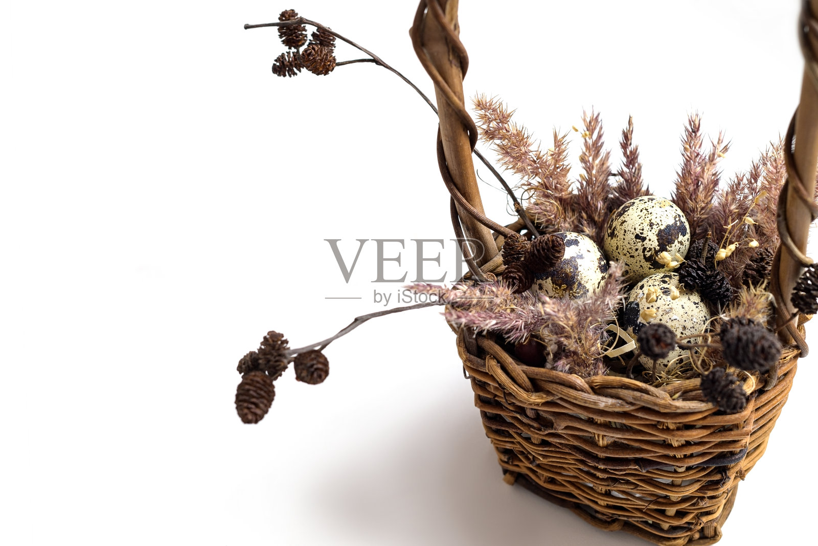 复活节柳条篮子，上面有小斑点蛋和蓬松的蒲苇草照片摄影图片