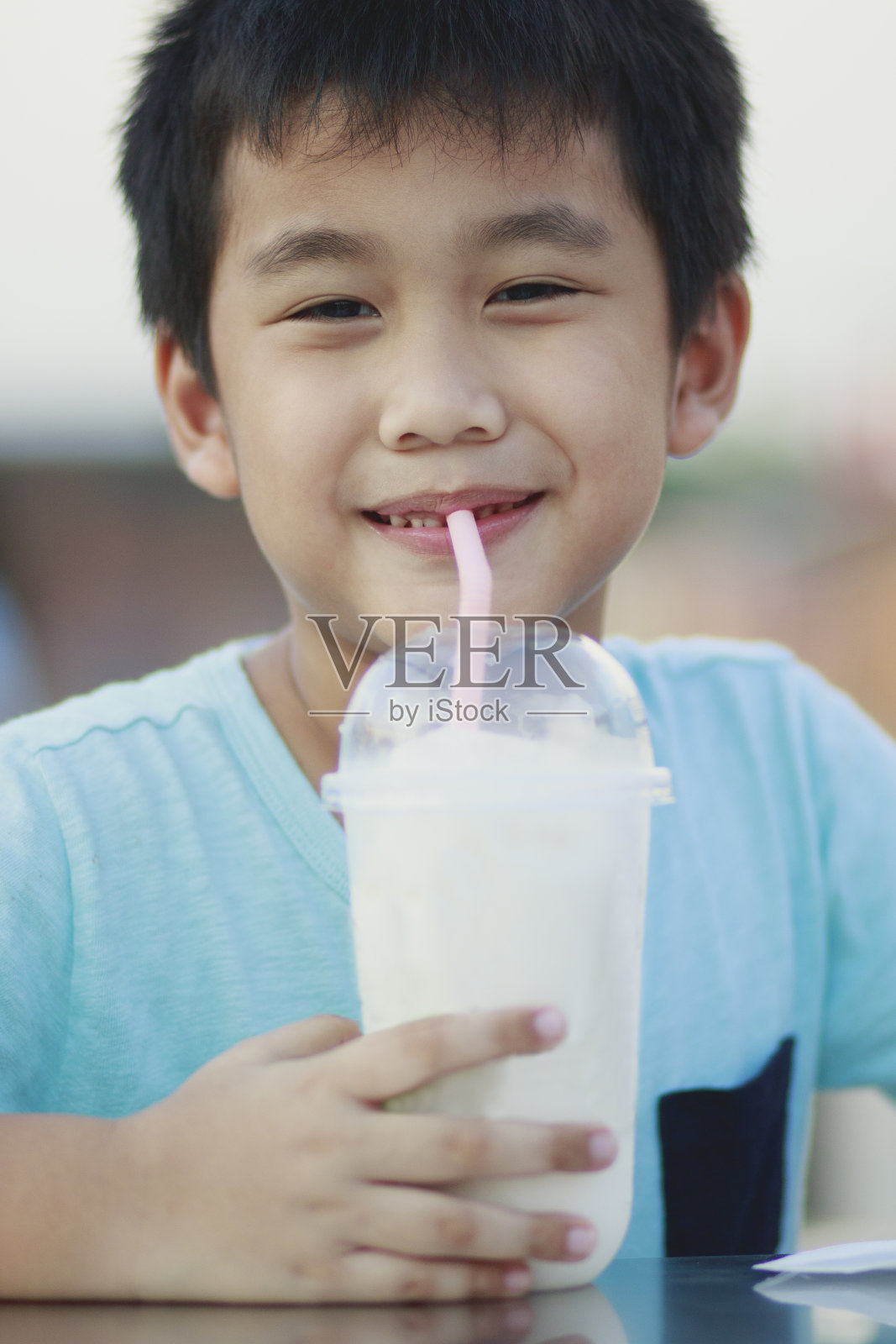 亚洲儿童在喝清凉饮料的塑料幼崽照片摄影图片
