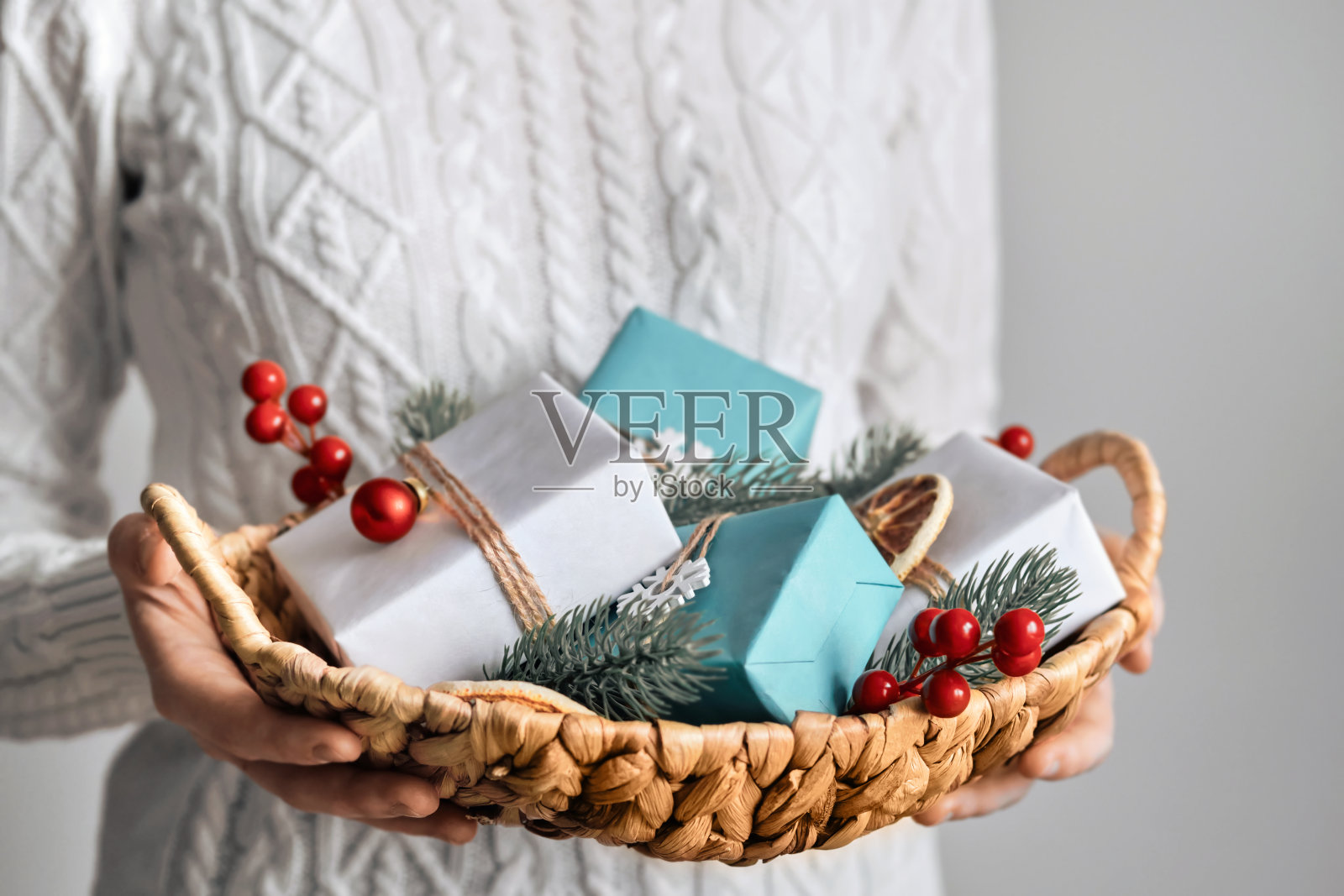 女人拿着一个装有可持续包装的圣诞礼物的篮子，特写镜头，选择性聚焦。Eco圣诞装饰照片摄影图片