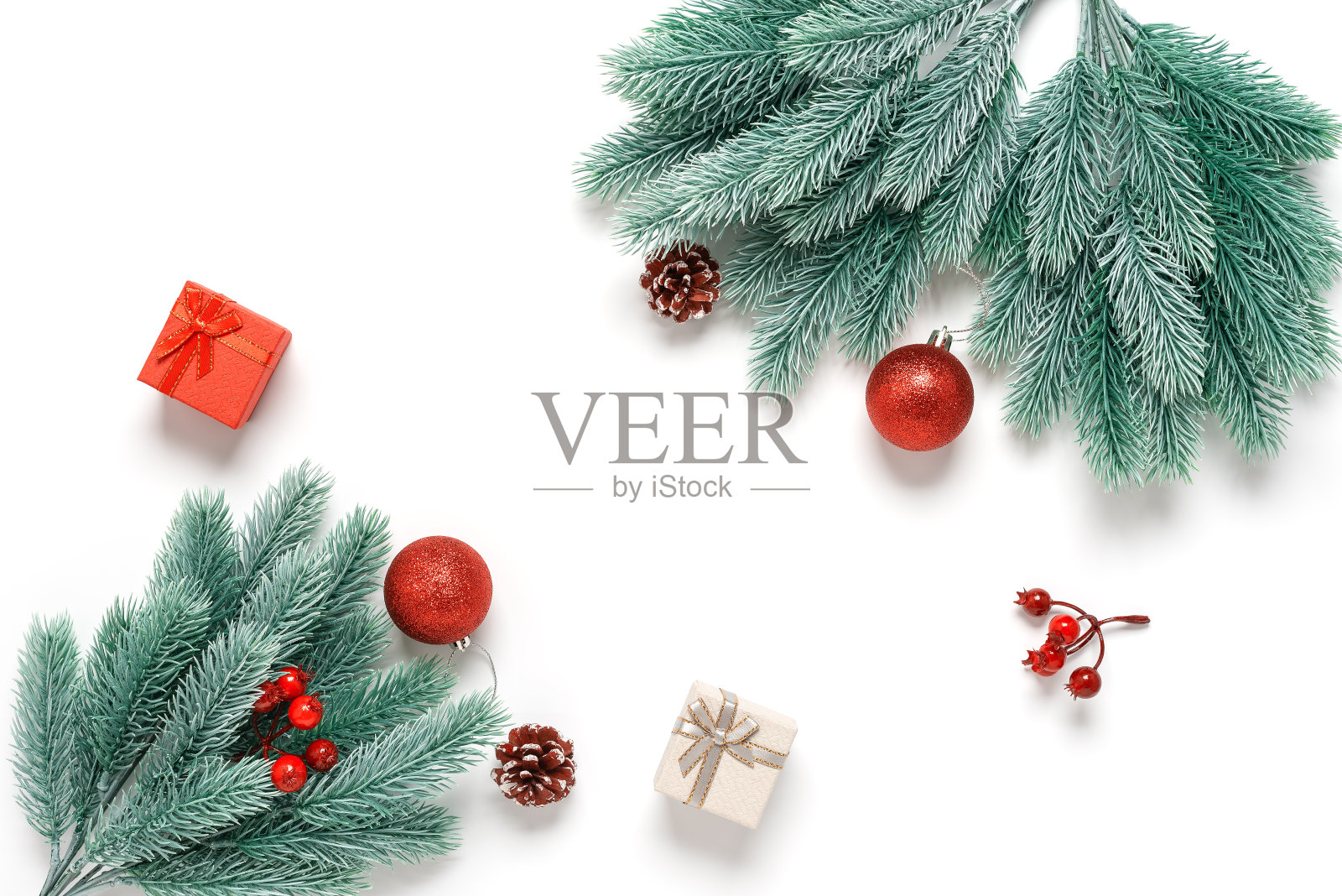圣诞组成。装饰性的冷杉树枝和红色的装饰品孤立在白色的背景上。俯视图，平躺。圣诞节、冬天和新年的概念照片摄影图片