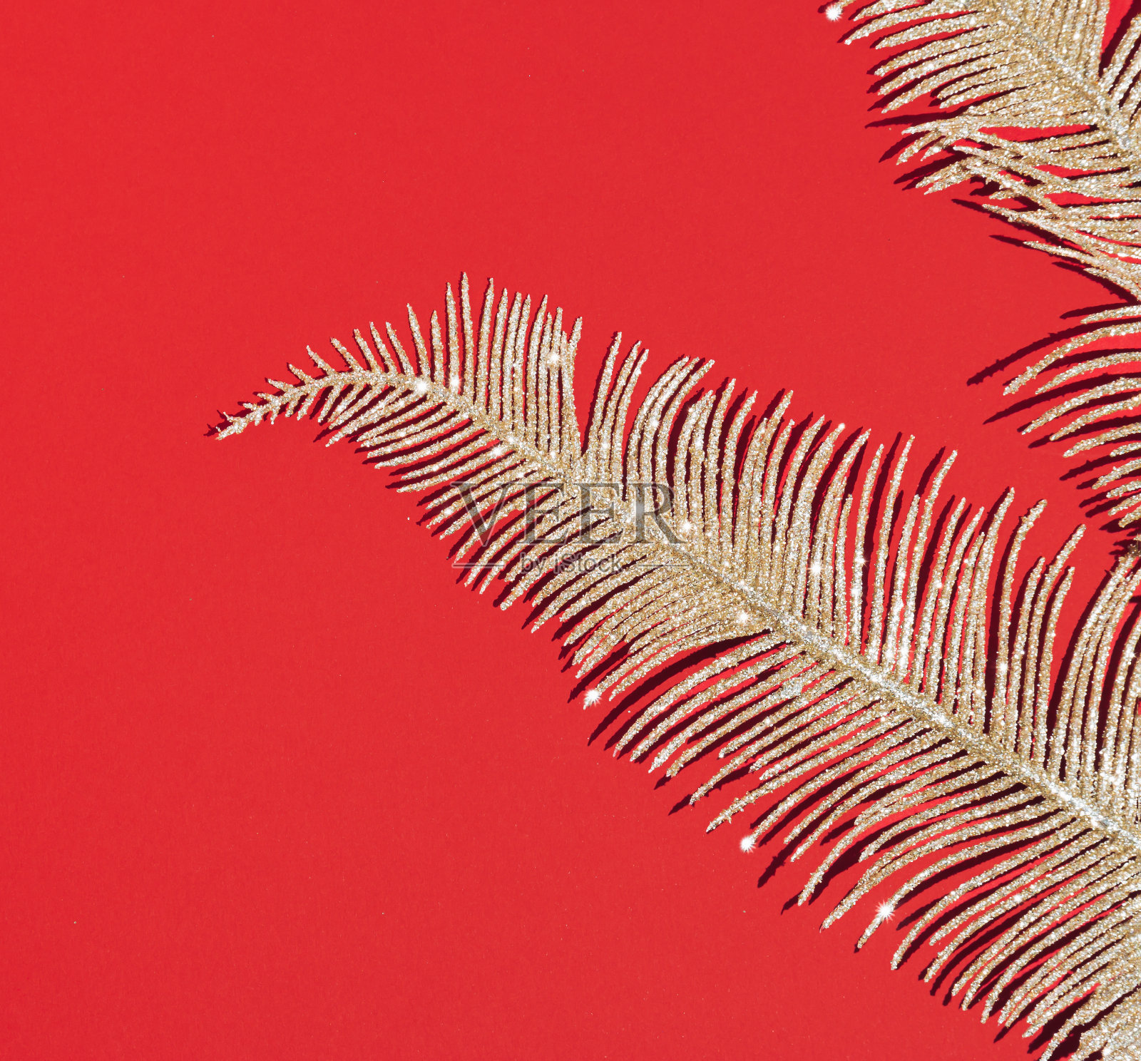 在圣诞节红色的背景上，金光闪闪的镯子。抽象的假日壁纸。剥躺的概念。照片摄影图片