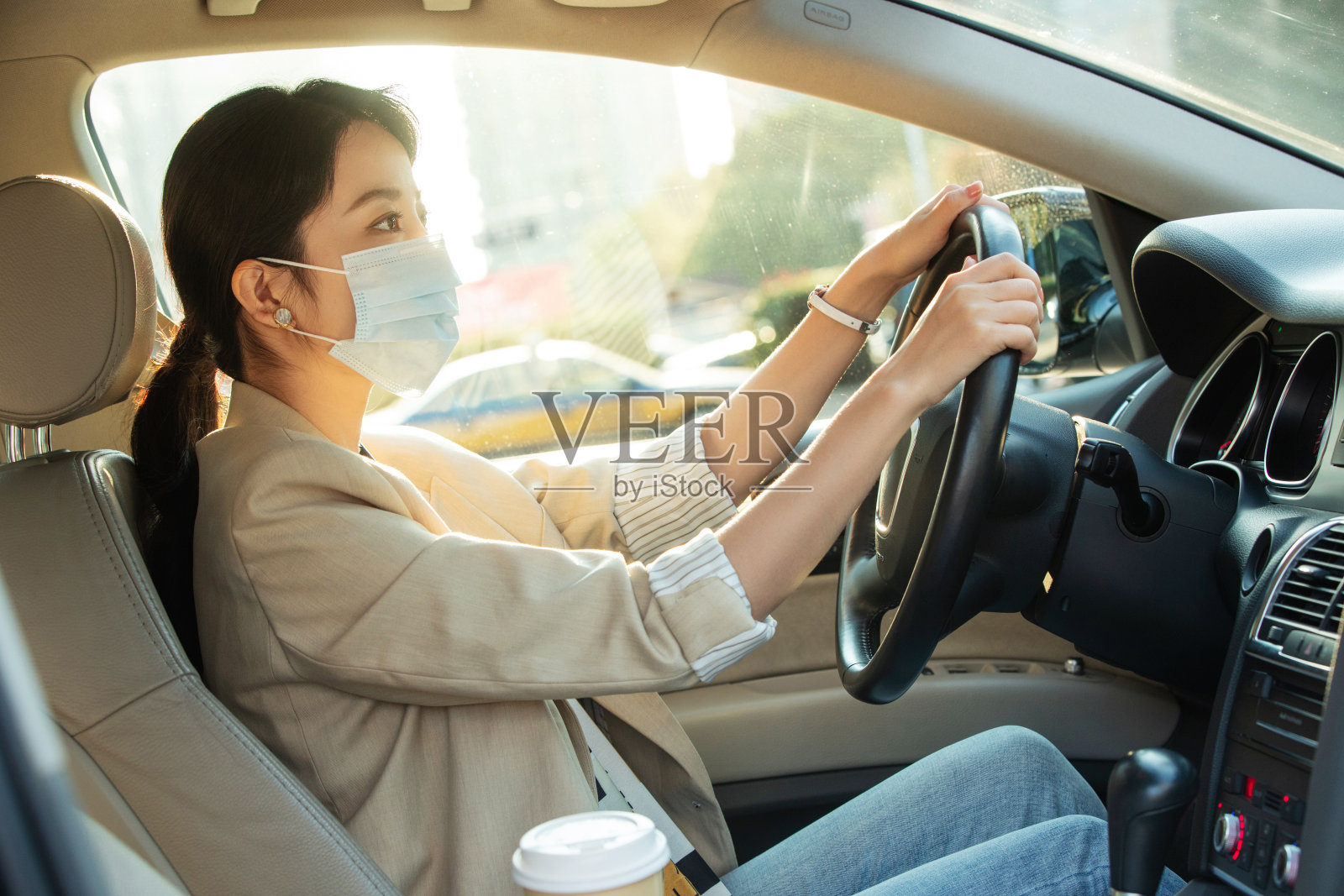 戴口罩开车的年轻女子照片摄影图片