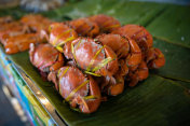 在泰国餐厅里，橙色红色的蒸蟹放在绿色香蕉叶的桌子上摄影图片