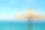 在克罗地亚Primosten市的沙滩上，一个海滩上的草伞映衬着蓝天和蔚蓝的海水。素材图片